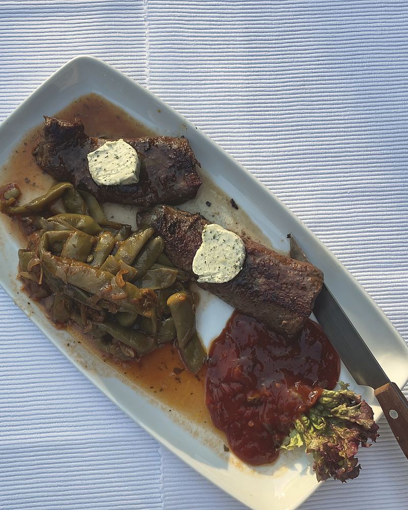 Lammsteak mit Kräuterbutter und grünen Bohnen in Tomatensauce