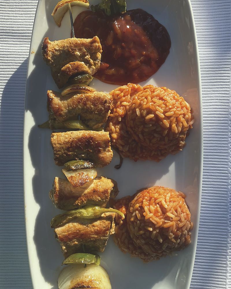 Gefülltes Souvlaki vom Spieß mit Paprika und Zwiebeln, dazu zwei Portionen Reis