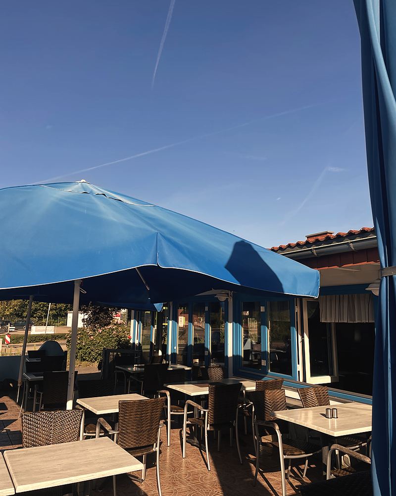 Die Terrasse mit Sonnenschirmen an der Seite des Hauses
